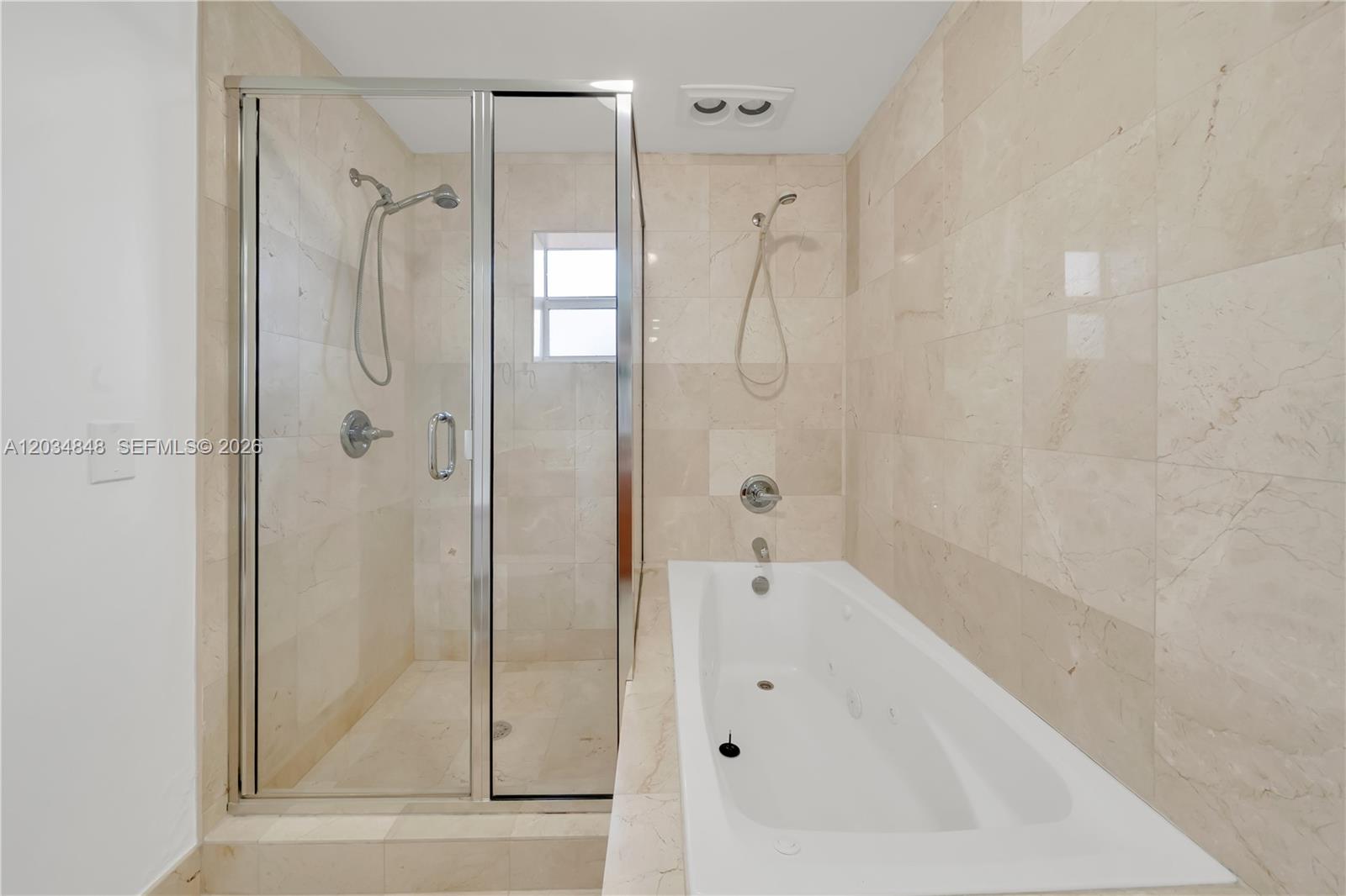 A bathroom features a glass-enclosed shower stall next to a white jetted bathtub — 7600 SW 19th Ter # C, Miami FL 33155, MIAMI, FL