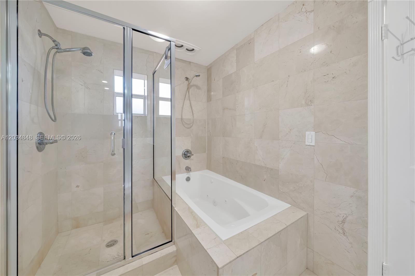 A bathroom features a glass-enclosed shower stall next to a tiled jetted bathtub — 7600 SW 19th Ter # C, Miami FL 33155, MIAMI, FL