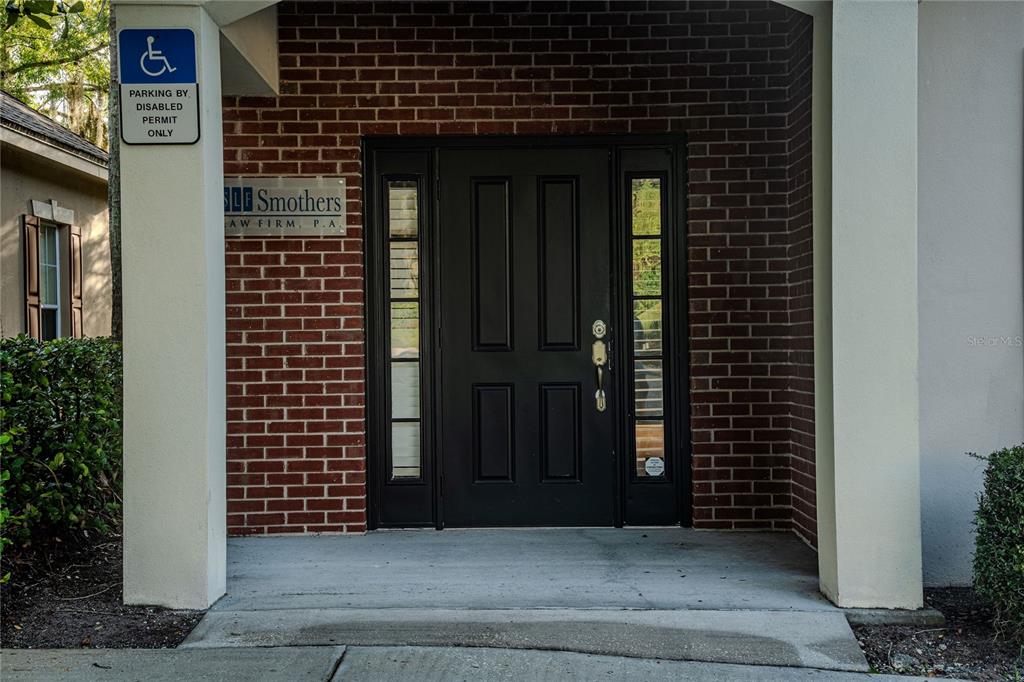 The exterior entrance features a brick facade, a black front door, and a handicap parking sign — 523 WEKIVA COMMONS CIRCLE UNIT 4, APOPKA, FL