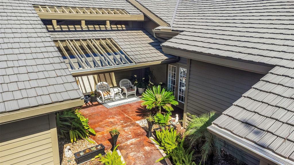 An aerial view shows a patio with a pergola, two chairs, and landscaping — 5331 SAND CRANE COURT, WESLEY CHAPEL, FL