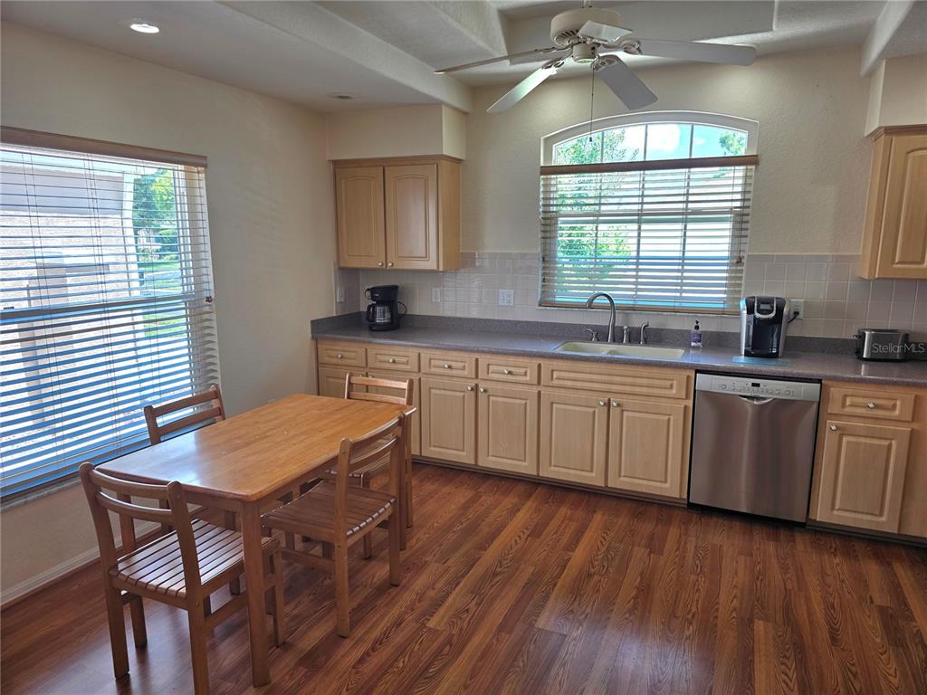 A kitchen features light wood cabinets, a dining table, and a stainless steel dishwasher — 225 ROYAL PALM WAY, SPRING HILL, FL