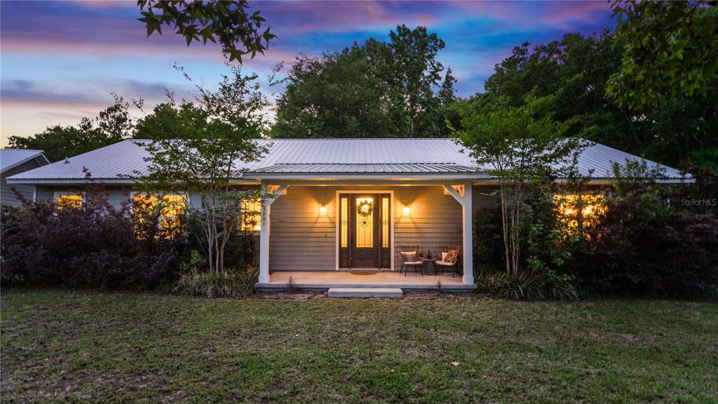 A single-story house with a metal roof and a covered front porch at dusk — 5901 SOLANA STREET, ELKTON, FL