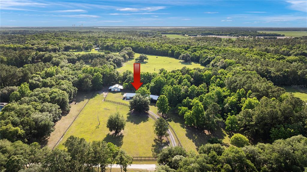 An aerial view shows a rural property with a house, outbuilding, and fenced pasture land — 5901 SOLANA STREET, ELKTON, FL