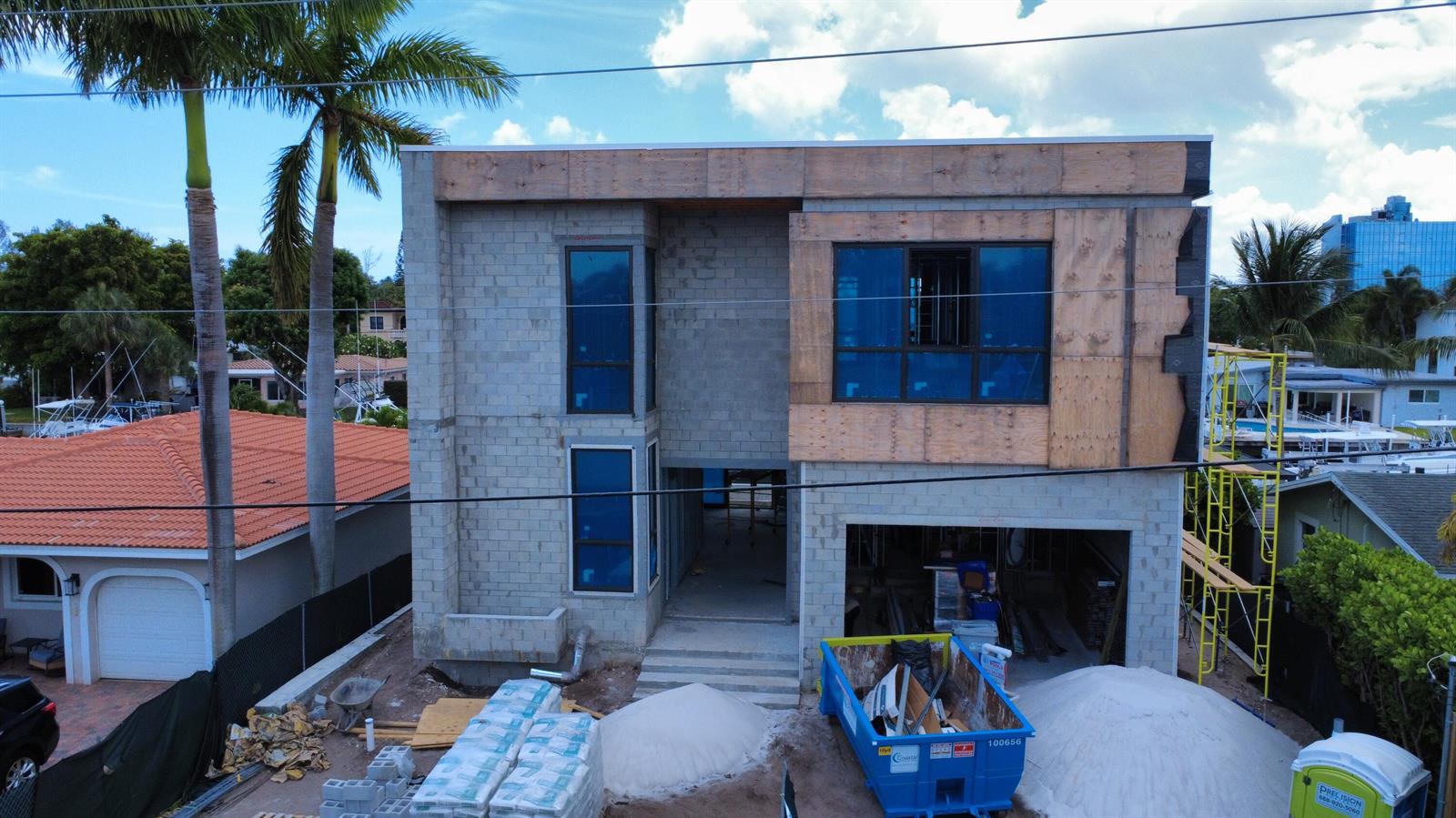 An exterior view of a two-story concrete block house under construction with blue-tinted windows — 2336 SE 13th Court, Pompano Beach FL 33062, POMPANO BEACH, FL