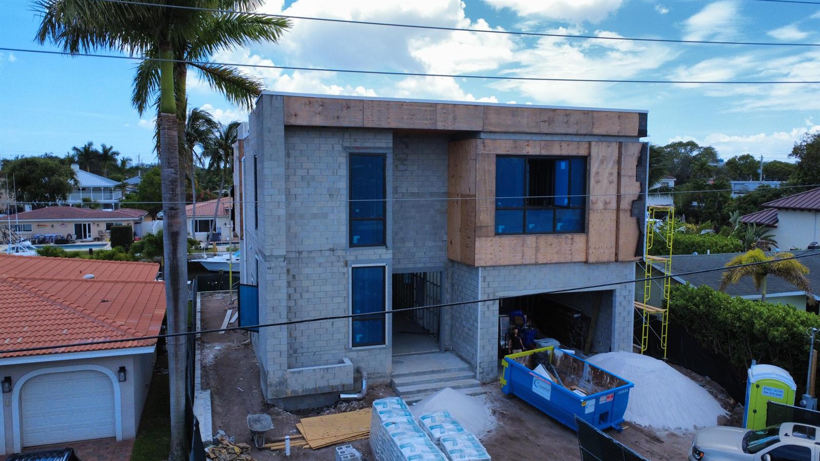 An aerial view shows a two-story concrete block house under construction with plywood exterior accents — 2336 SE 13th Court, Pompano Beach FL 33062, POMPANO BEACH, FL