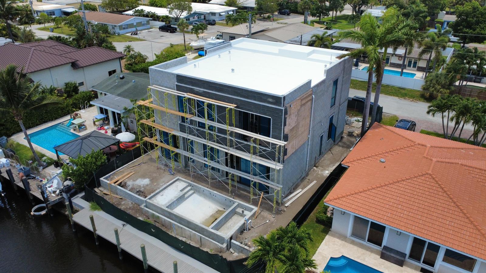 An aerial view shows a multi-story concrete house under construction with a pool and dock — 2336 SE 13th Court, Pompano Beach FL 33062, POMPANO BEACH, FL