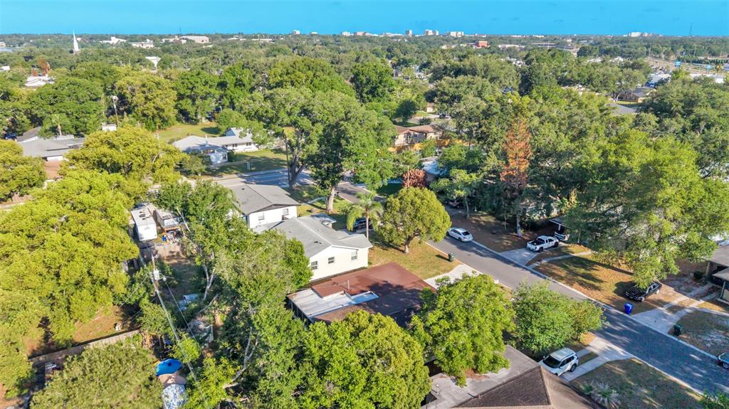 An aerial view shows several houses surrounded by many trees in a suburban neighborhood — 1615 SKINNER STREET, LAKELAND, FL