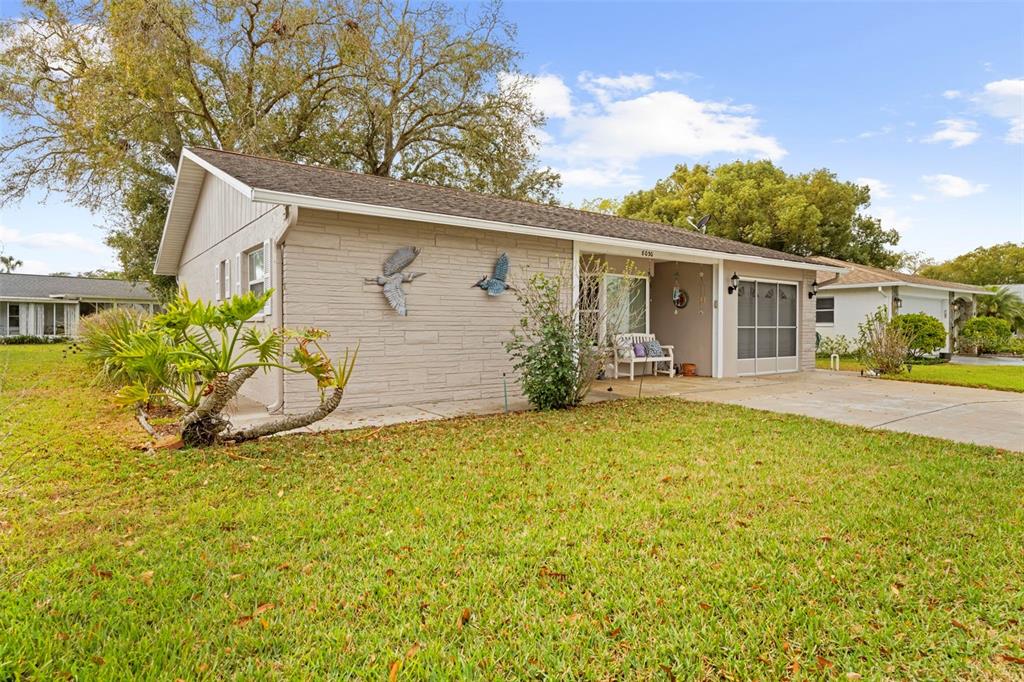 A single-story house with light-colored siding, a covered porch, and a grassy front yard — 8030 GLENEAGLE DRIVE, PORT RICHEY, FL