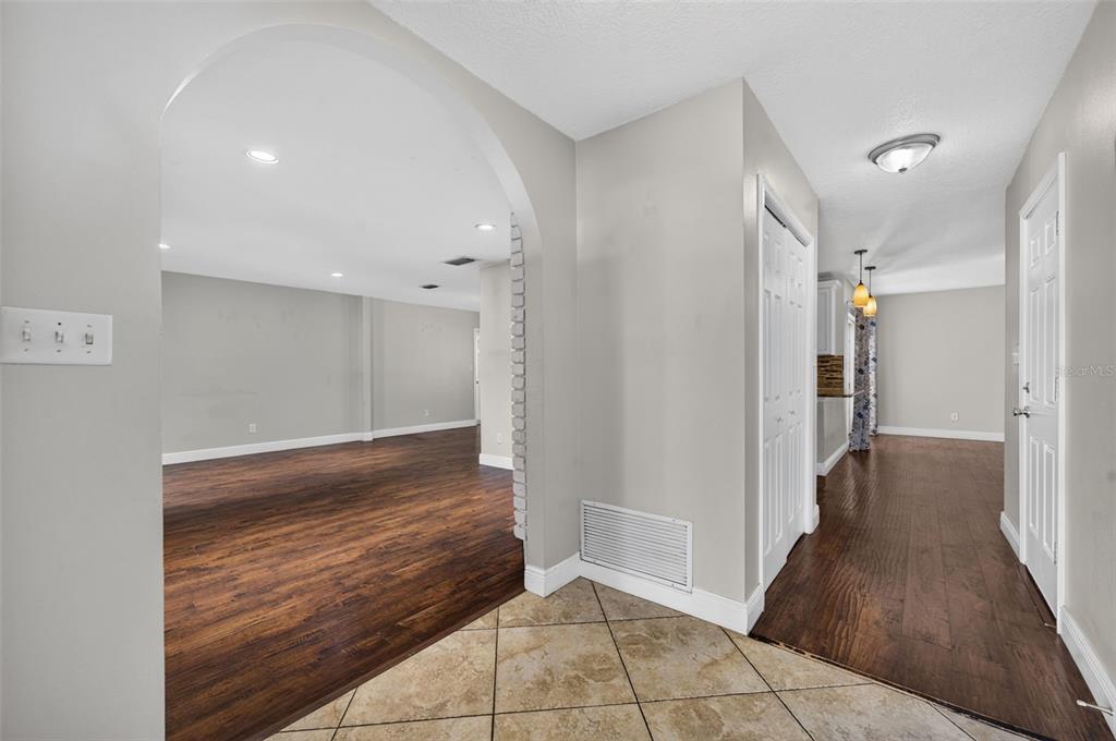 An interior view showing a tiled entryway, an arched opening to a room, and hardwood floors — 112 ROOSEVELT PLACE, MAITLAND, FL