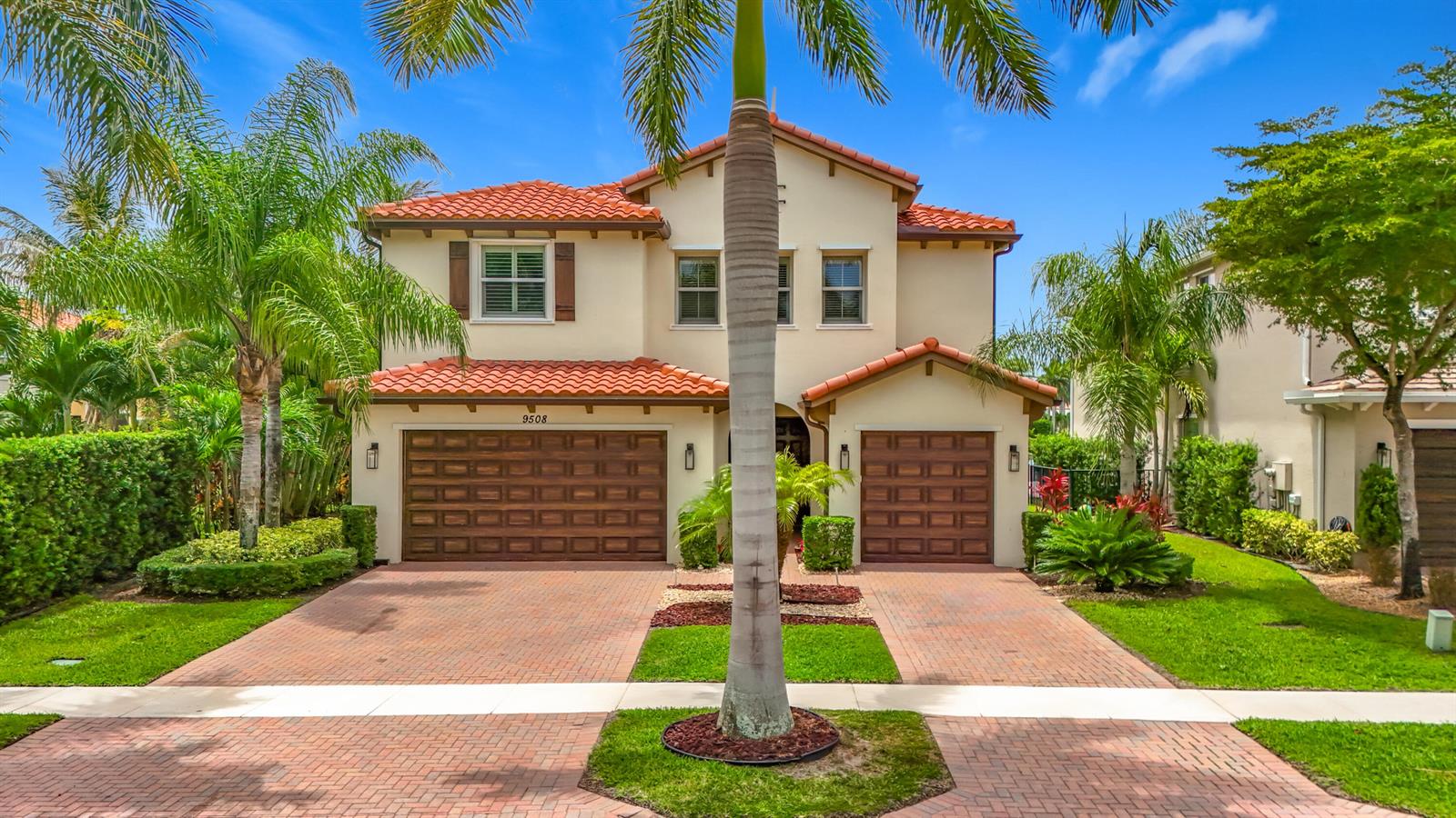 A two-story house with a red tile roof, brown garage doors, and a paved driveway — 9508 Phipps Lane, Wellington FL 33414, WELLINGTON, FL