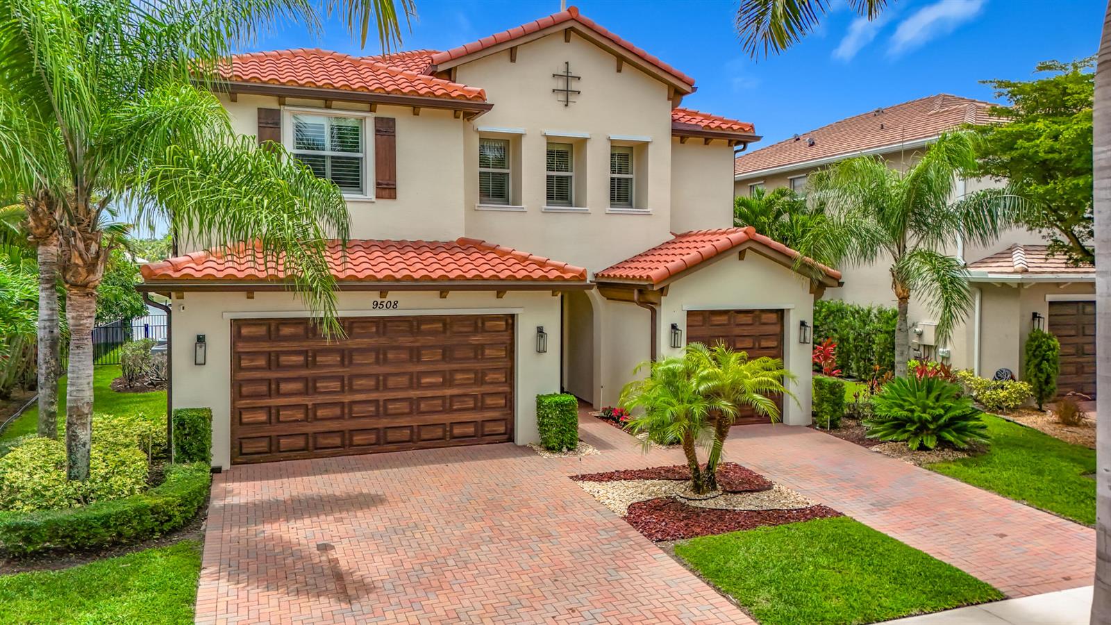 A two-story house with a red tile roof, beige stucco exterior, and a brick driveway — 9508 Phipps Lane, Wellington FL 33414, WELLINGTON, FL
