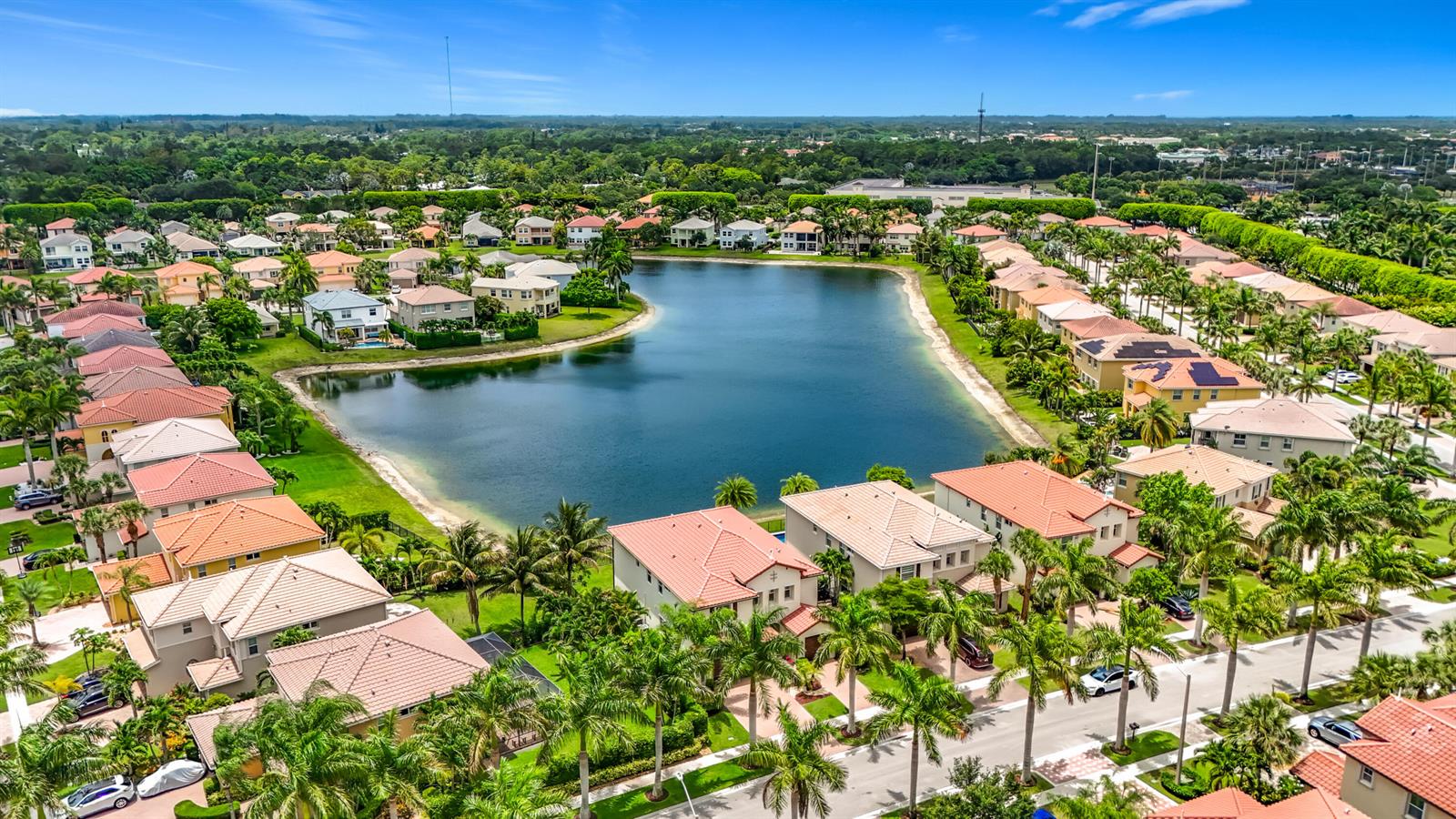 An aerial view shows a residential neighborhood with houses surrounding a central lake — 9508 Phipps Lane, Wellington FL 33414, WELLINGTON, FL