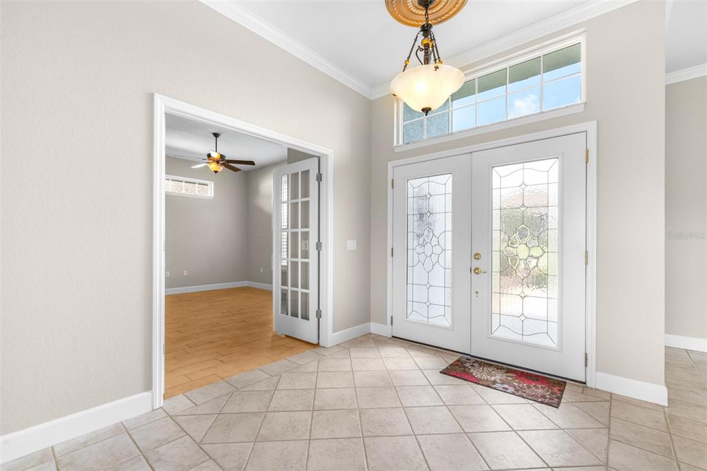 An entryway with tile flooring, a chandelier, and double doors leading to a room — 2636 HUNTINGTON HILLS DRIVE, LAKELAND, FL