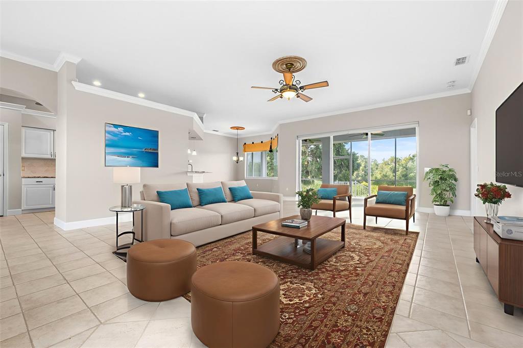 A living room features a beige sofa, two armchairs, a coffee table, and tile flooring — 2636 HUNTINGTON HILLS DRIVE, LAKELAND, FL