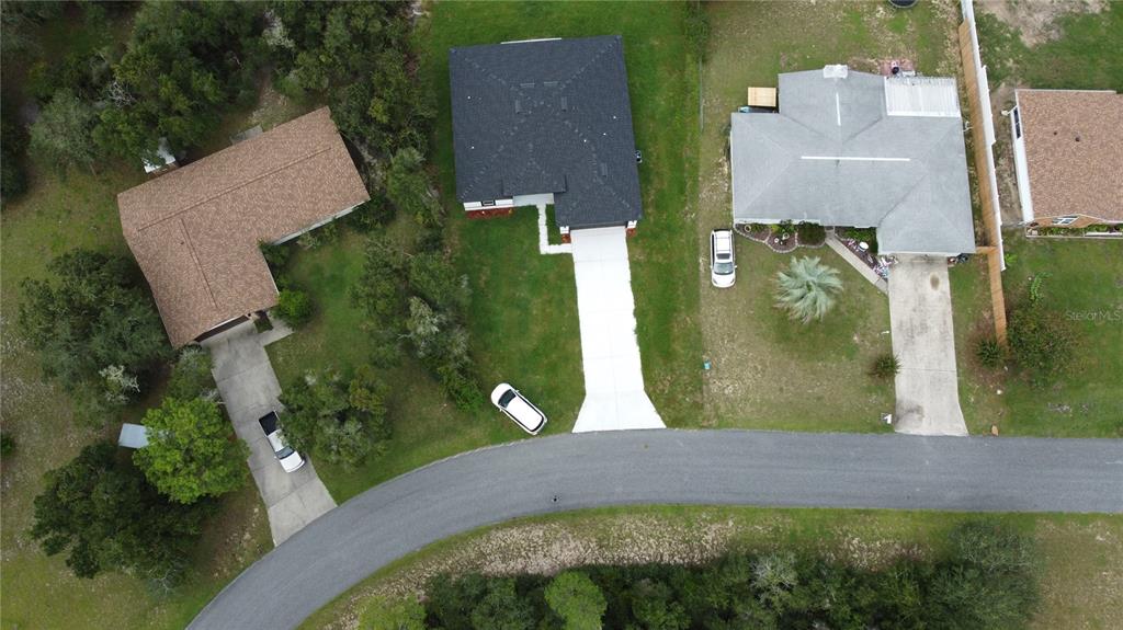 An aerial view shows three houses with driveways and lawns along a curved street — 15716 SW 46TH AVENUE ROAD, OCALA, FL