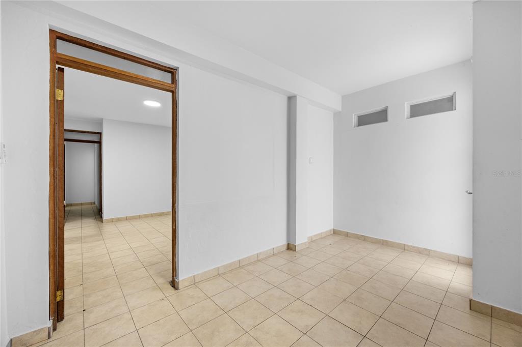 An interior view shows a room with beige tile flooring and a wooden door frame — CAPARRA HEIGHTS J-42 ESCORIAL AVENUE UNIT 603, SAN JUAN, PR