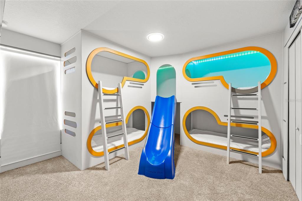 A children's bedroom features custom built-in bunk beds with a central blue slide — 1568 FLANGE DRIVE, DAVENPORT, FL