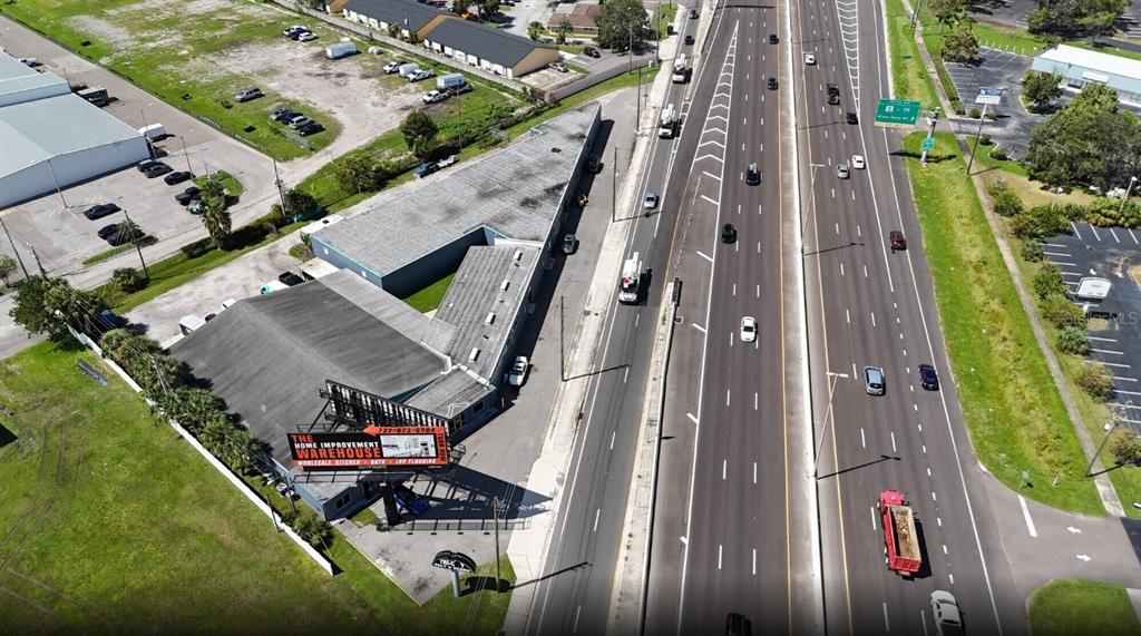 An aerial view shows a commercial building with a large billboard next to a highway — 10300 US HIGHWAY 19 N, PINELLAS PARK, FL
