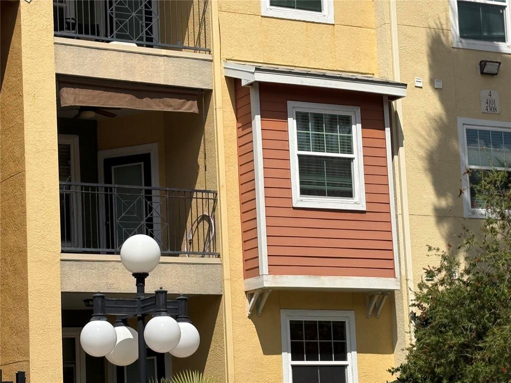 A multi-story apartment building exterior features a balcony, a bay window, and a street lamp — 1810 E PALM AVENUE UNIT 4201, TAMPA, FL