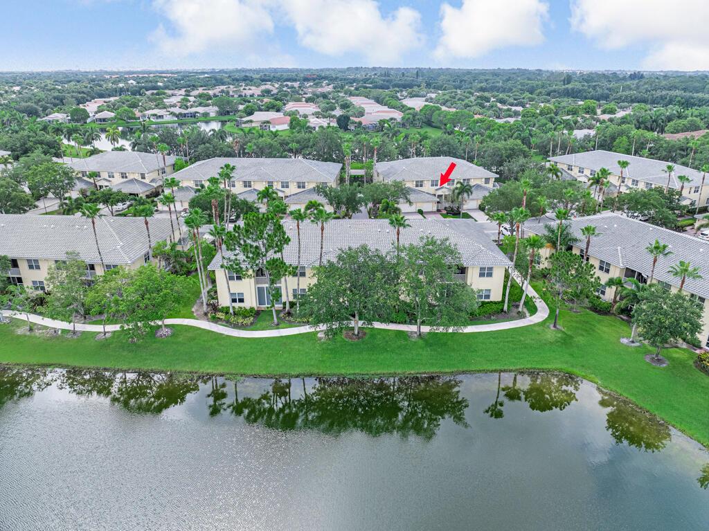 An aerial view shows a multi-story residential building complex situated next to a lake — 9778 Bowline Drive # 201, West Palm Beach FL 33411, WEST PALM BEACH, FL