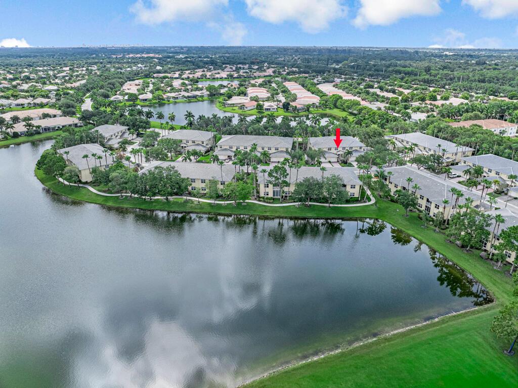 An aerial view of a multi-unit residential complex situated along a large lake — 9778 Bowline Drive # 201, West Palm Beach FL 33411, WEST PALM BEACH, FL