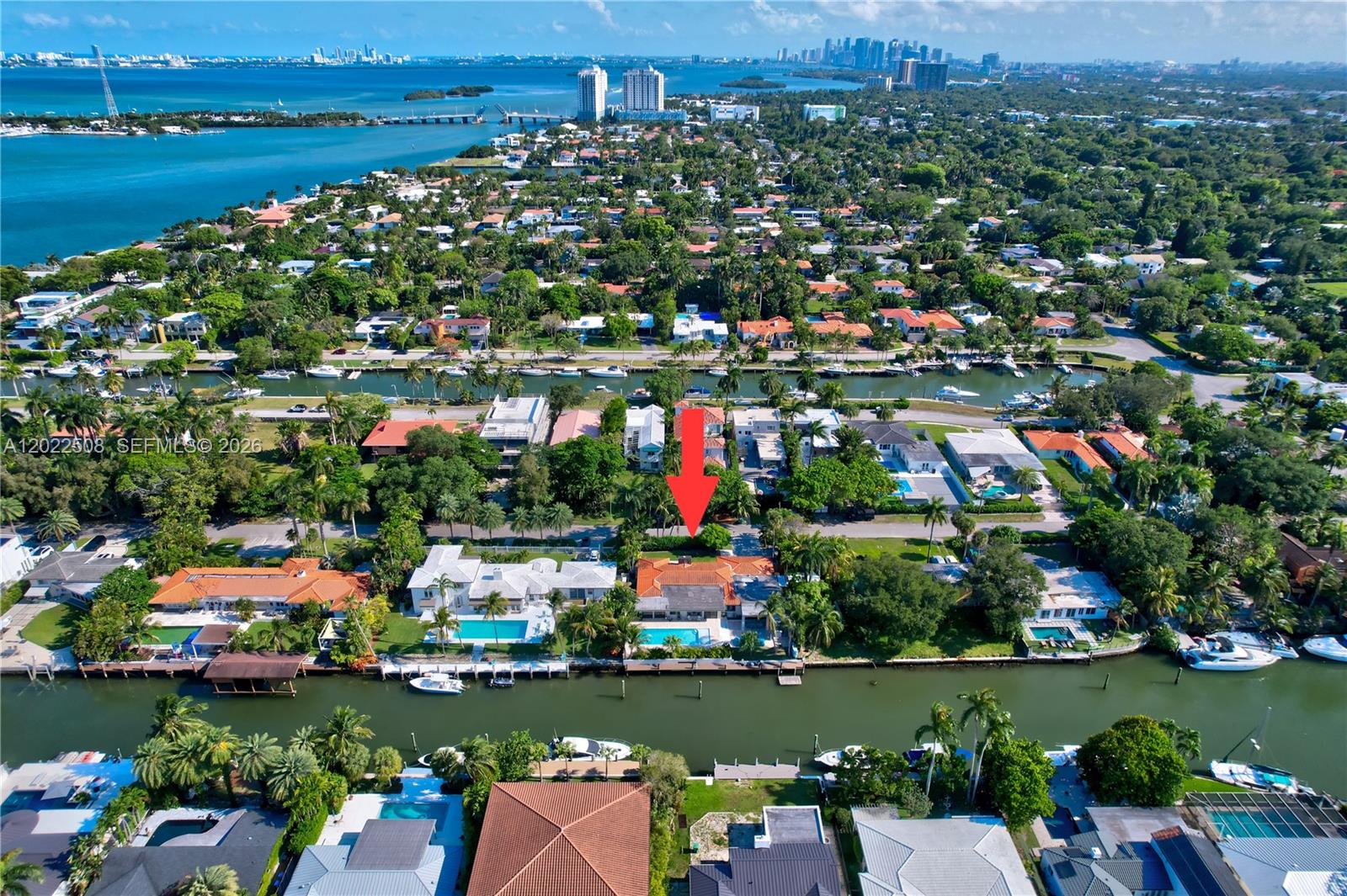 An aerial view shows a waterfront house with a pool and a red arrow — 1141 NE 90th St, Miami FL 33138, MIAMI, FL