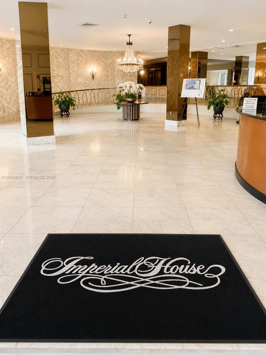 A lobby with marble floors, a chandelier, and a black mat featuring the Imperial House logo — 5255 Collins Ave # 7B, Miami Beach FL 33140, MIAMI BEACH, FL