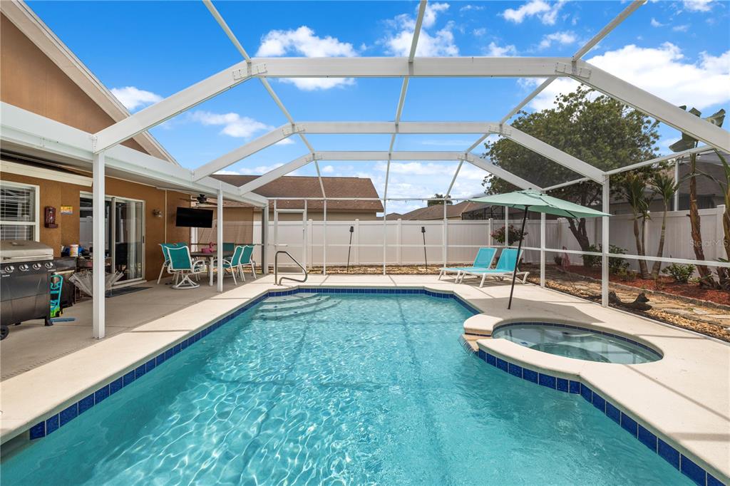 A screened-in swimming pool and spa with a patio area and outdoor furniture — 22741 RODERICK DRIVE, LAND O LAKES, FL