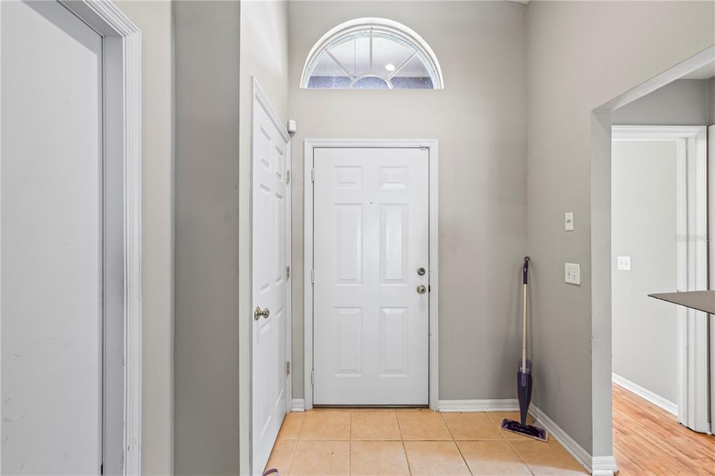 An entryway features a white front door, a transom window, and light-colored tile flooring — 22741 RODERICK DRIVE, LAND O LAKES, FL