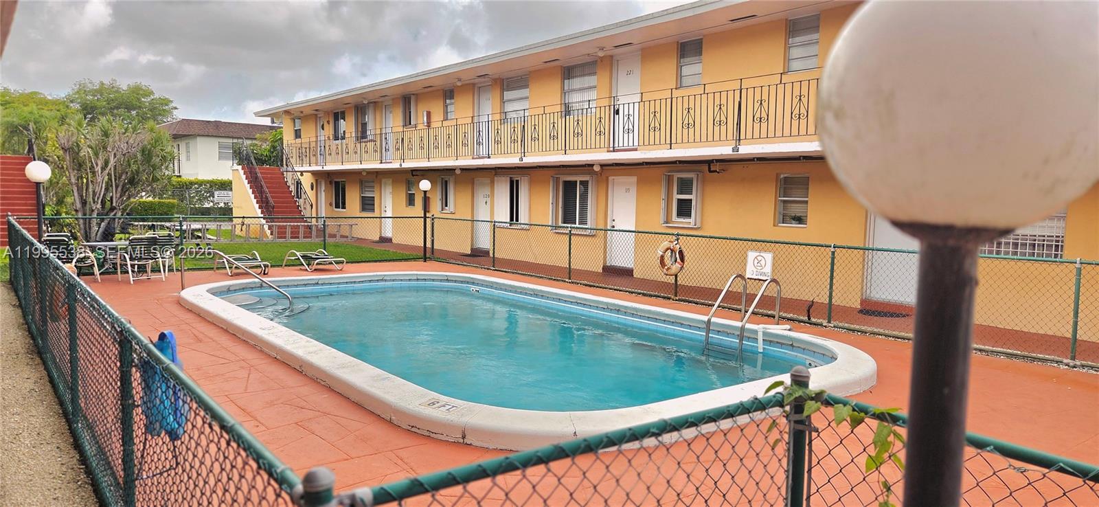 A two-story yellow apartment building features a swimming pool in the fenced courtyard — 3800 SW 102nd Ave # 108, Miami FL 33165, MIAMI, FL