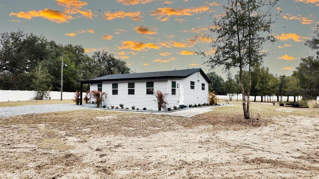 A single-story house with light gray siding and a dark roof sits on a lot — 2607 NE 140TH STREET, CITRA, FL
