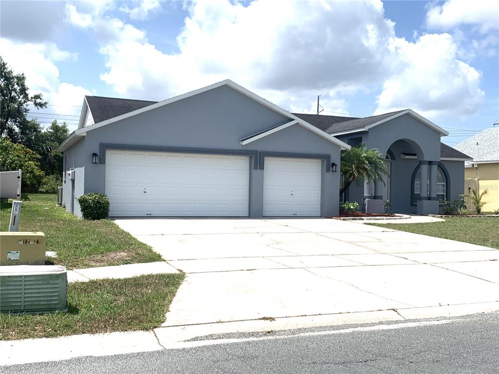 A single-story house with a gray exterior, two white garage doors, and a concrete driveway — 11513 ANDY DRIVE, RIVERVIEW, FL