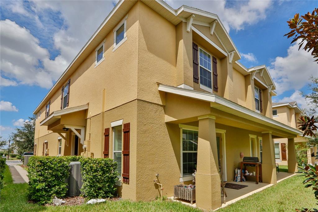 A two-story tan stucco townhouse with a covered patio and brown shutters — 4724 SOMERSET HILL LANE, RIVERVIEW, FL
