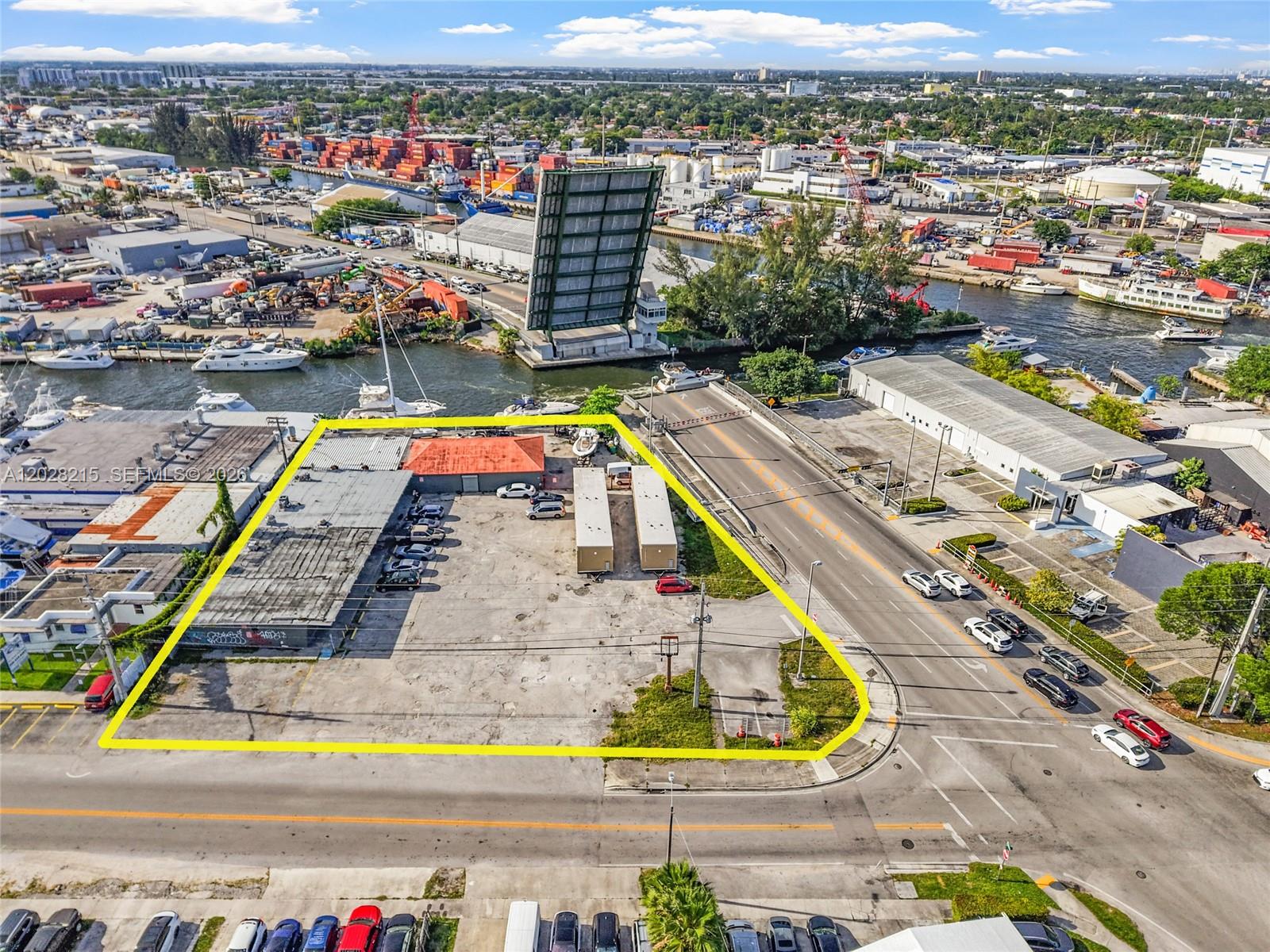 An aerial view shows a fenced commercial lot with a building and two storage containers — 3066 NW River Dr, Miami FL 33142, MIAMI, FL