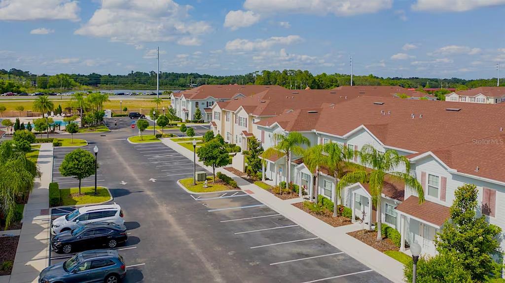 An aerial view shows a multi-unit residential complex with a parking lot and palm trees — 3201 GOLD LANE, KISSIMMEE, FL