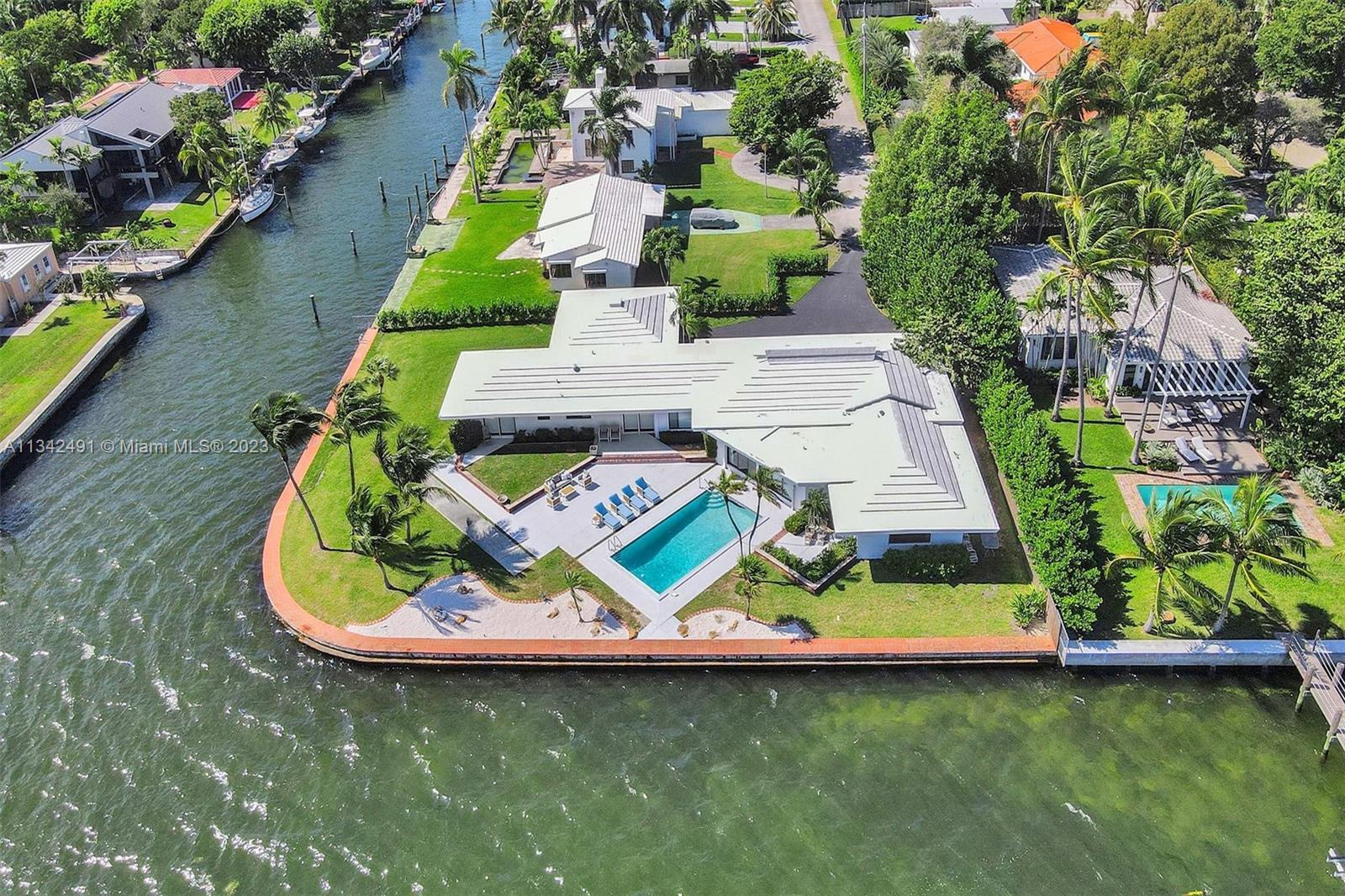 An aerial view shows a waterfront house with a swimming pool and a boat dock — 9101 N Bayshore Dr, Miami FL 33138, MIAMI, FL