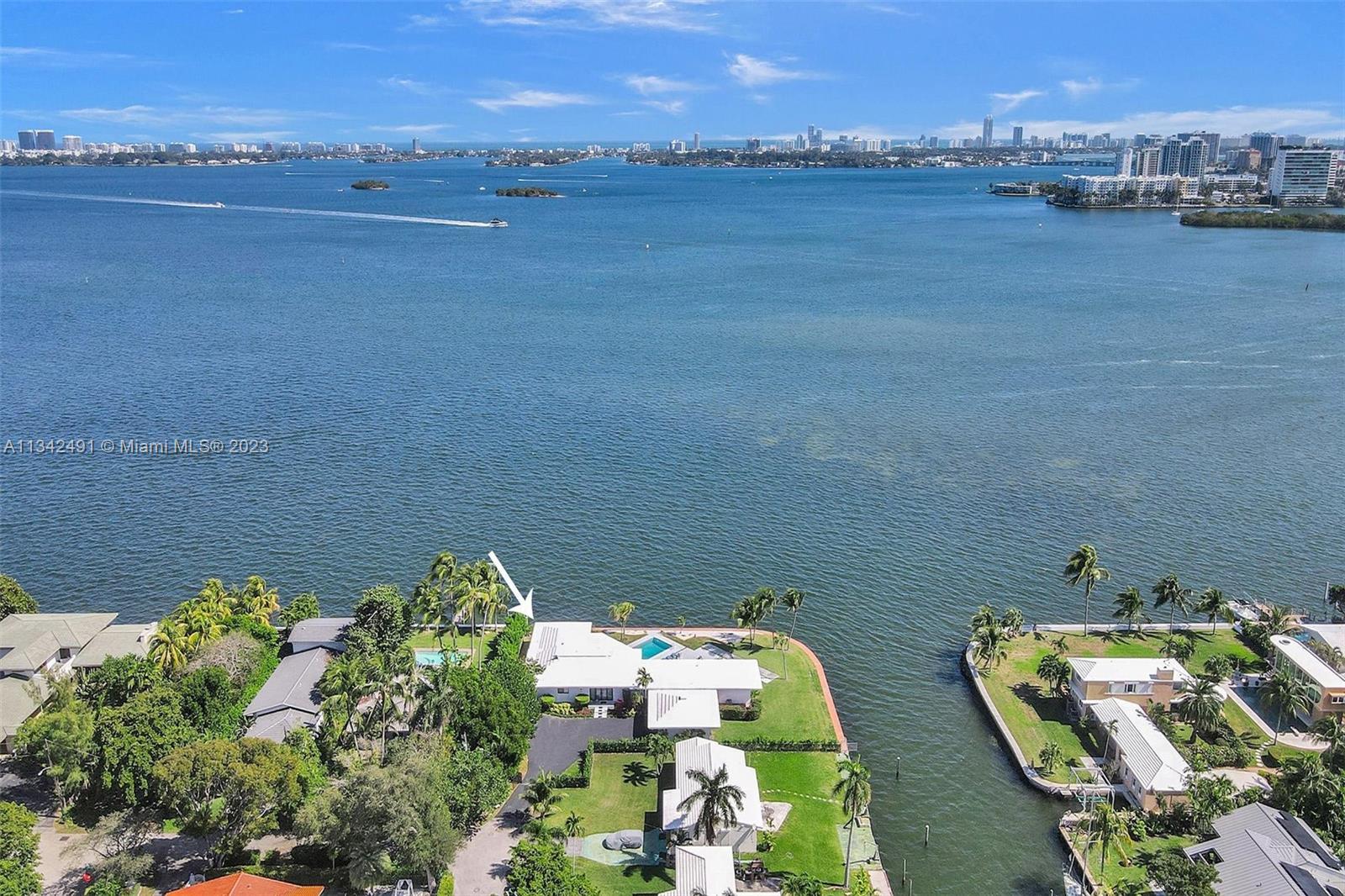 An aerial view shows a waterfront house with a pool and a white roof — 9101 N Bayshore Dr, Miami FL 33138, MIAMI, FL