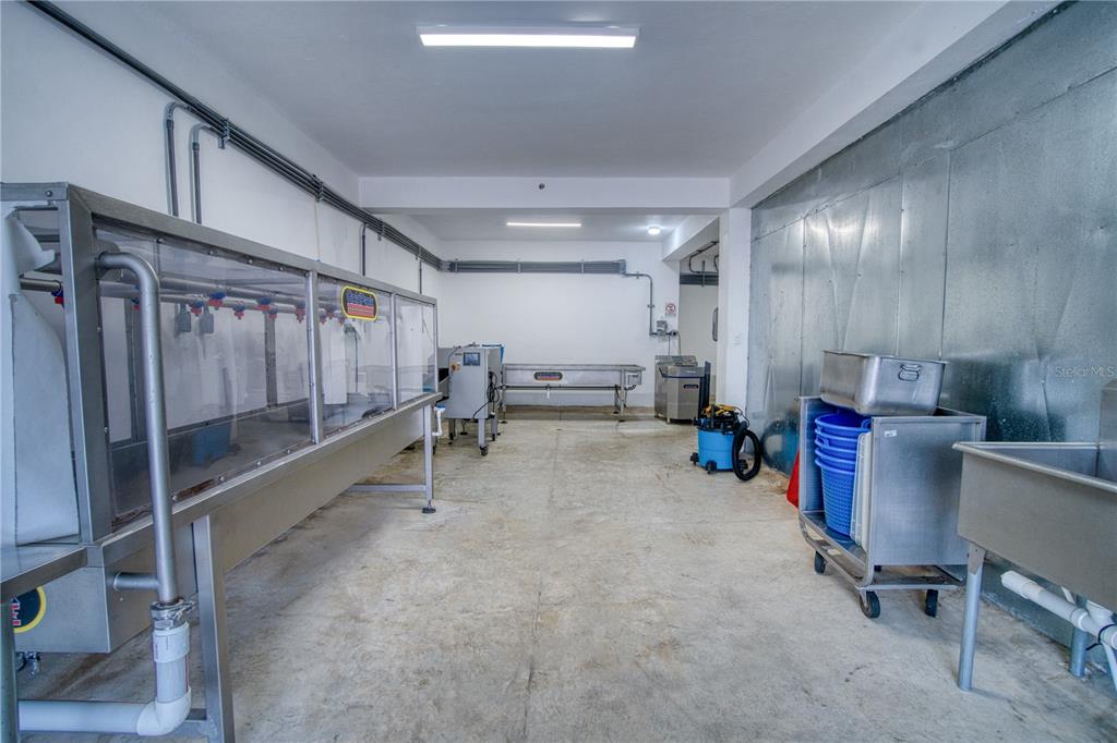 A commercial kitchen space features stainless steel equipment, concrete floors, and metal wall paneling — Sector Palmasola BO. BUENOS AIRES, LARES, PR