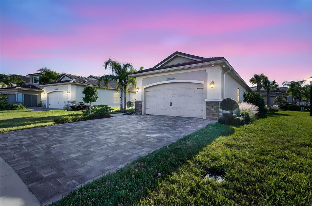 A single-story house with a paved driveway, two-car garage, and a landscaped front lawn — 30724 LINDENTREE DRIVE, WESLEY CHAPEL, FL