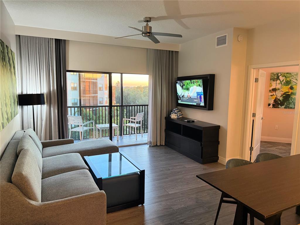 A living room features a gray sectional sofa, a glass coffee table, and a balcony — 14501 GROVE RESORT AVENUE UNIT 2536, WINTER GARDEN, FL