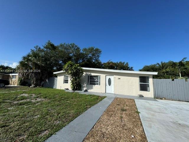 A single-story house with a white exterior, a concrete driveway, and a small front lawn — 26 Virginia Rd, West Park FL 33023, WEST PARK, FL