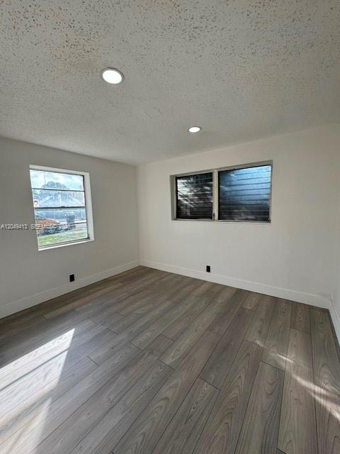 An empty room features light wood-look flooring, white walls, and two windows — 26 Virginia Rd, West Park FL 33023, WEST PARK, FL