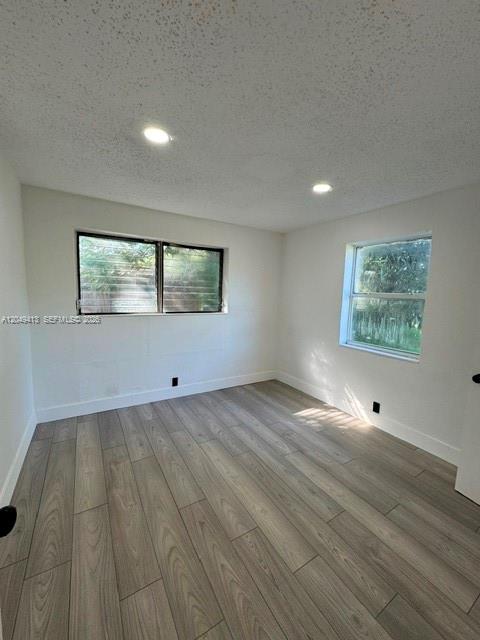 An empty bedroom features white walls, recessed lighting, and light wood-look flooring — 26 Virginia Rd, West Park FL 33023, WEST PARK, FL