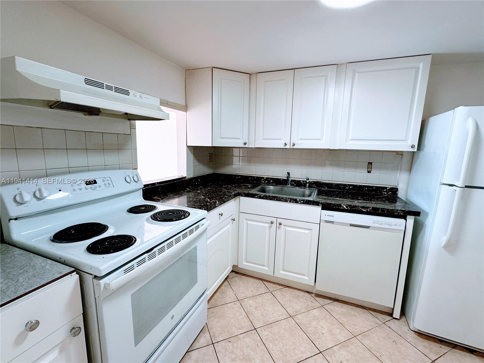 A kitchen features white cabinets, dark countertops, a white stove, and a white refrigerator — 4364 NW 9th Ave # 3F, Deerfield Beach FL 33064, DEERFIELD BEACH, FL