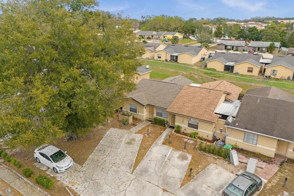An aerial view shows a duplex with a large tree and concrete driveways — 1267 WOODMAN WAY, ORLANDO, FL