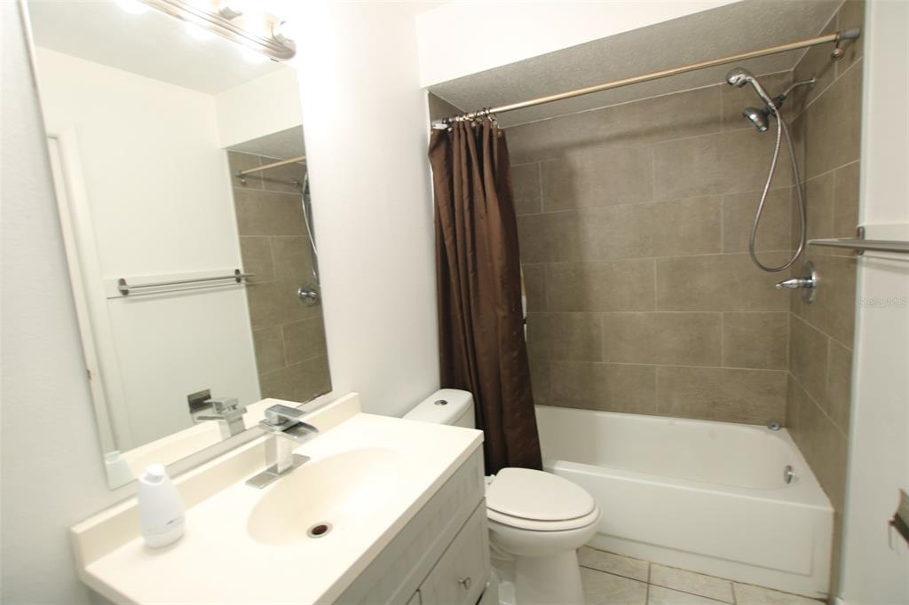 A bathroom features a vanity with a white sink, a toilet, and a tiled shower-tub — 53 W MARBRISA WAY, KISSIMMEE, FL