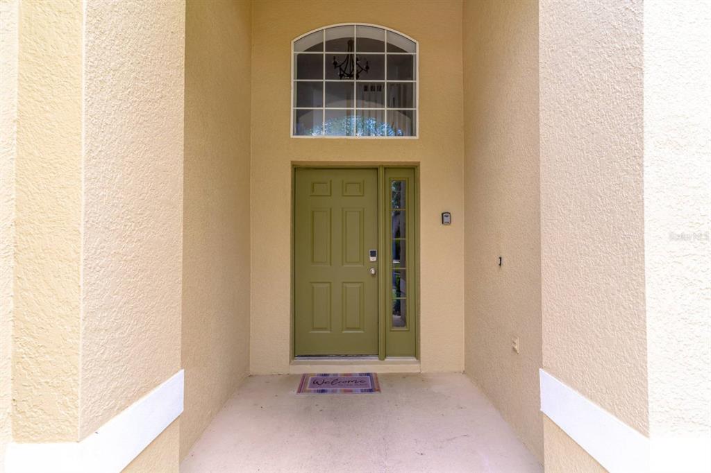 A front entryway features a green door with a sidelight and an arched transom window — 8512 SUNRISE KEY DRIVE, KISSIMMEE, FL