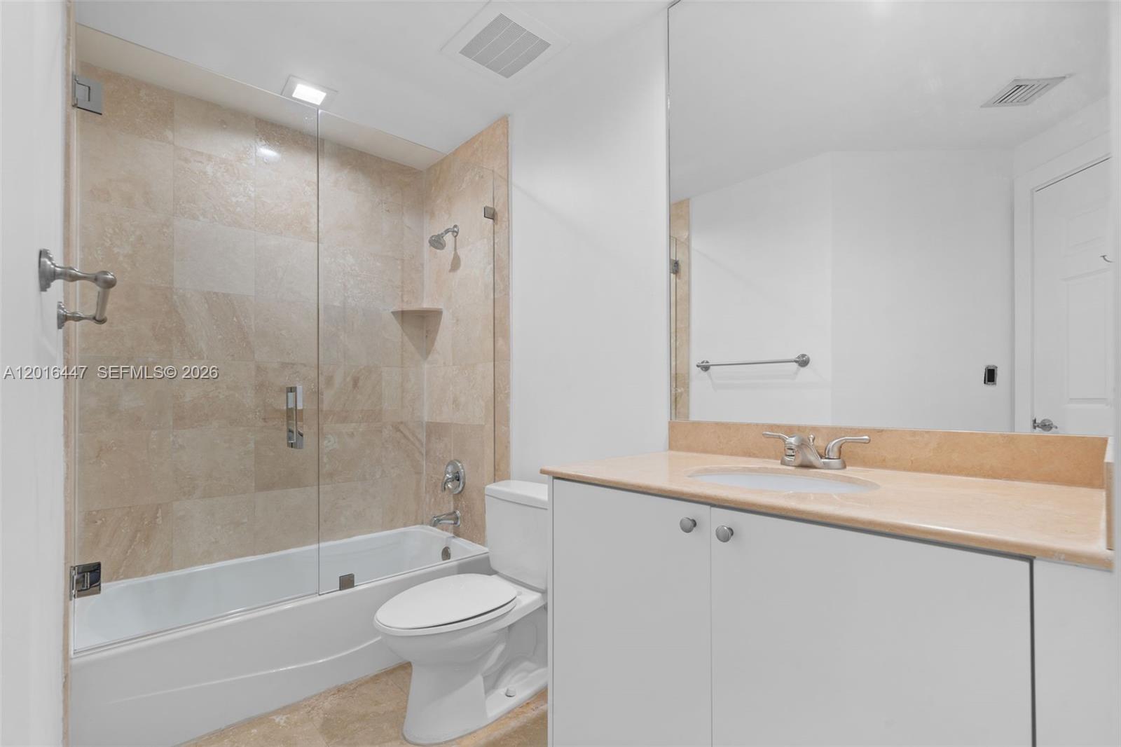 A bathroom features a glass-enclosed shower-tub combination, a white vanity, and beige tile flooring — 1745 E Hallandale Beach Blvd PH, Hallandale Beach FL 33009, HALLANDALE BEACH, FL