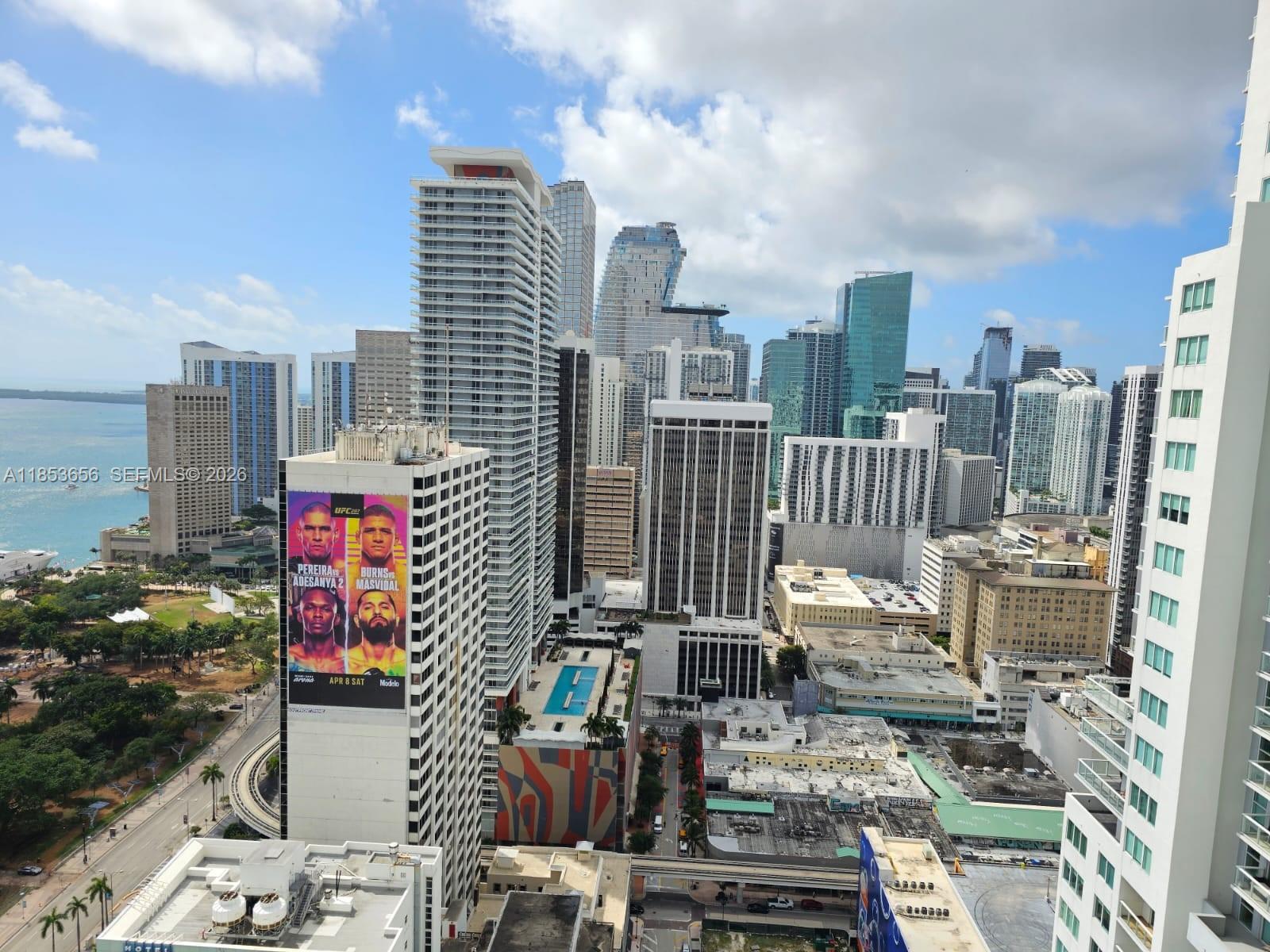 An elevated view of the Miami skyline featuring high-rise buildings and a large UFC advertisement — 244 Biscayne Blvd # 3707, Miami FL 33132, MIAMI, FL