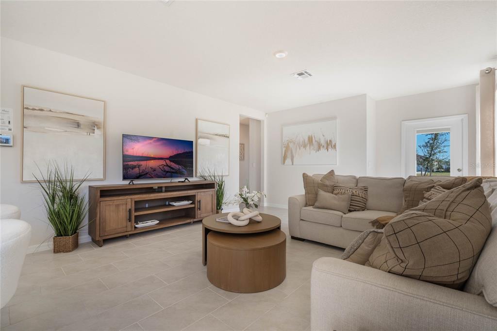 A living room features a television on a wooden console, a coffee table, and sofa — 3023 VICEROY, POINCIANA, FL